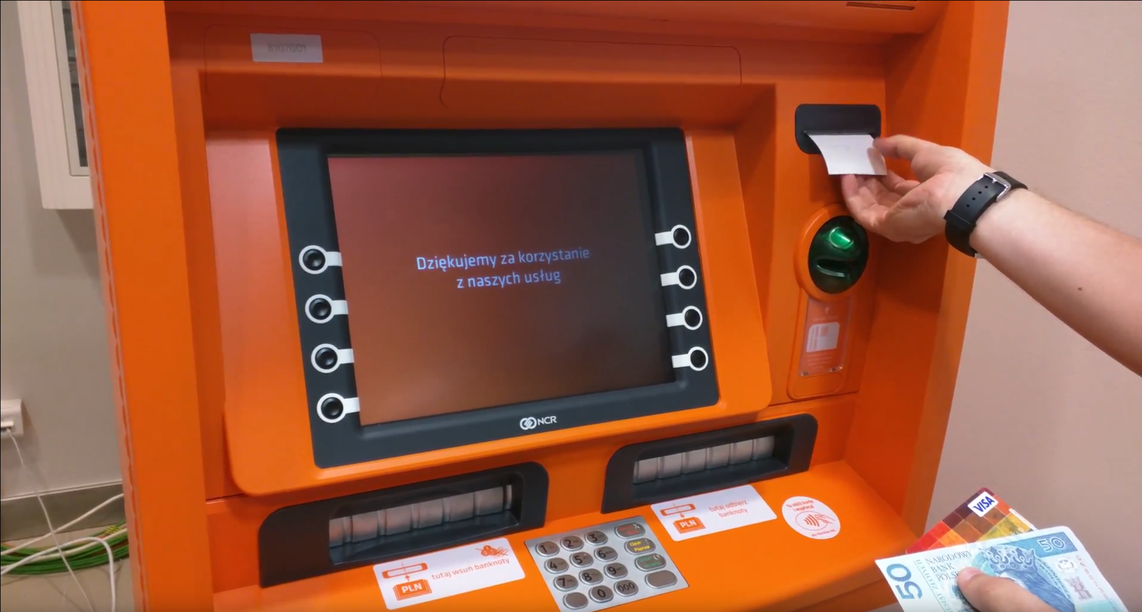 A man's hand taking out money of a test ATM